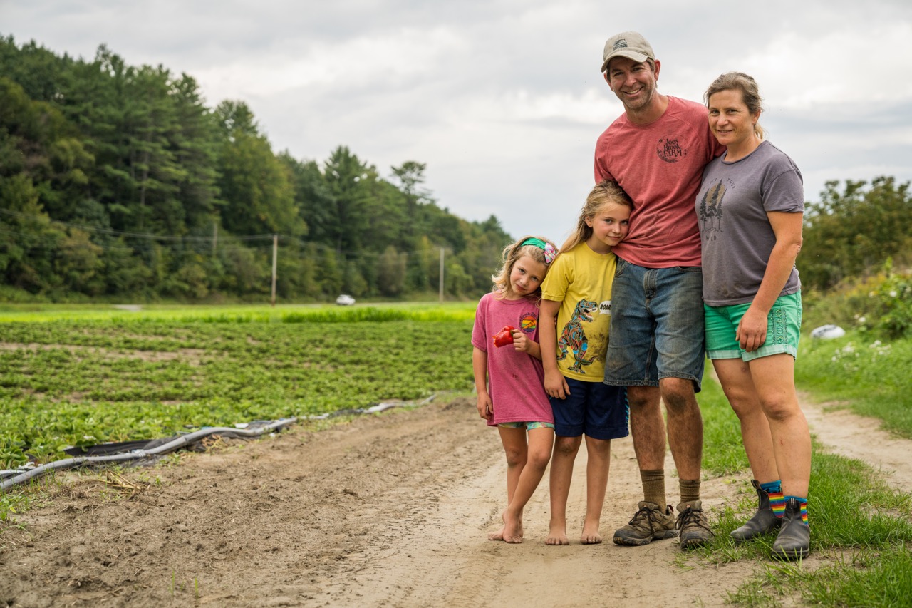 Skosted Family outisde in the farm field on a sunny day