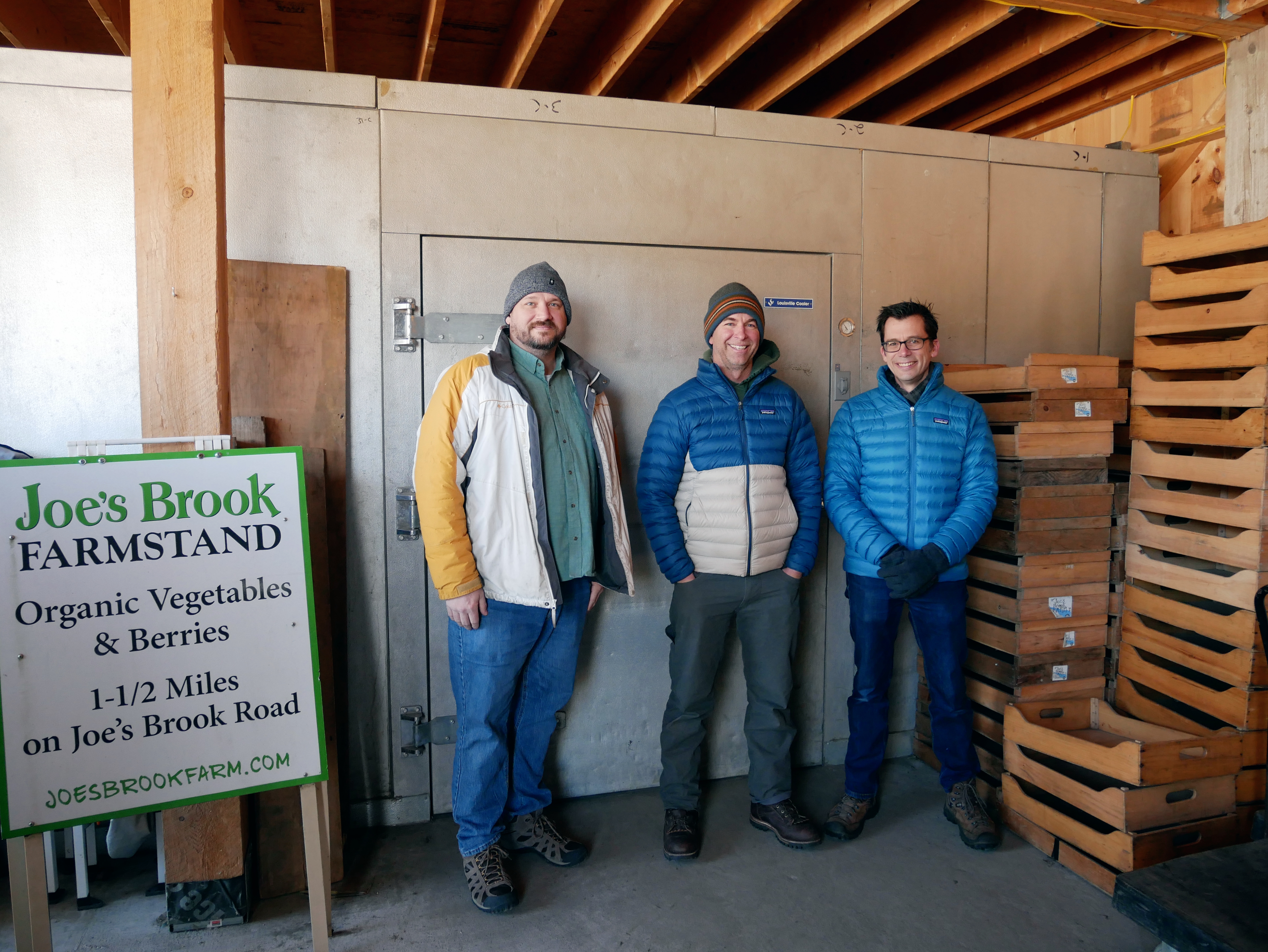 Todd Campbell, Pete Schweigert, and Eric Skovsted stand in a greenhouse