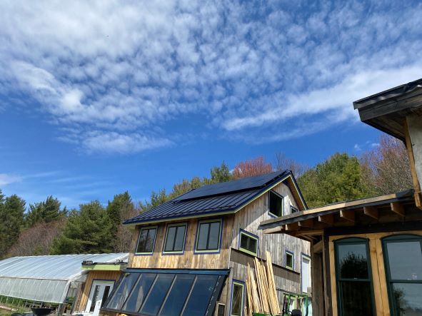 Solar panels on a barn roof with blue sky in the background