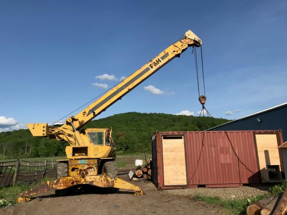 A crane lowers a modular kiln to the ground