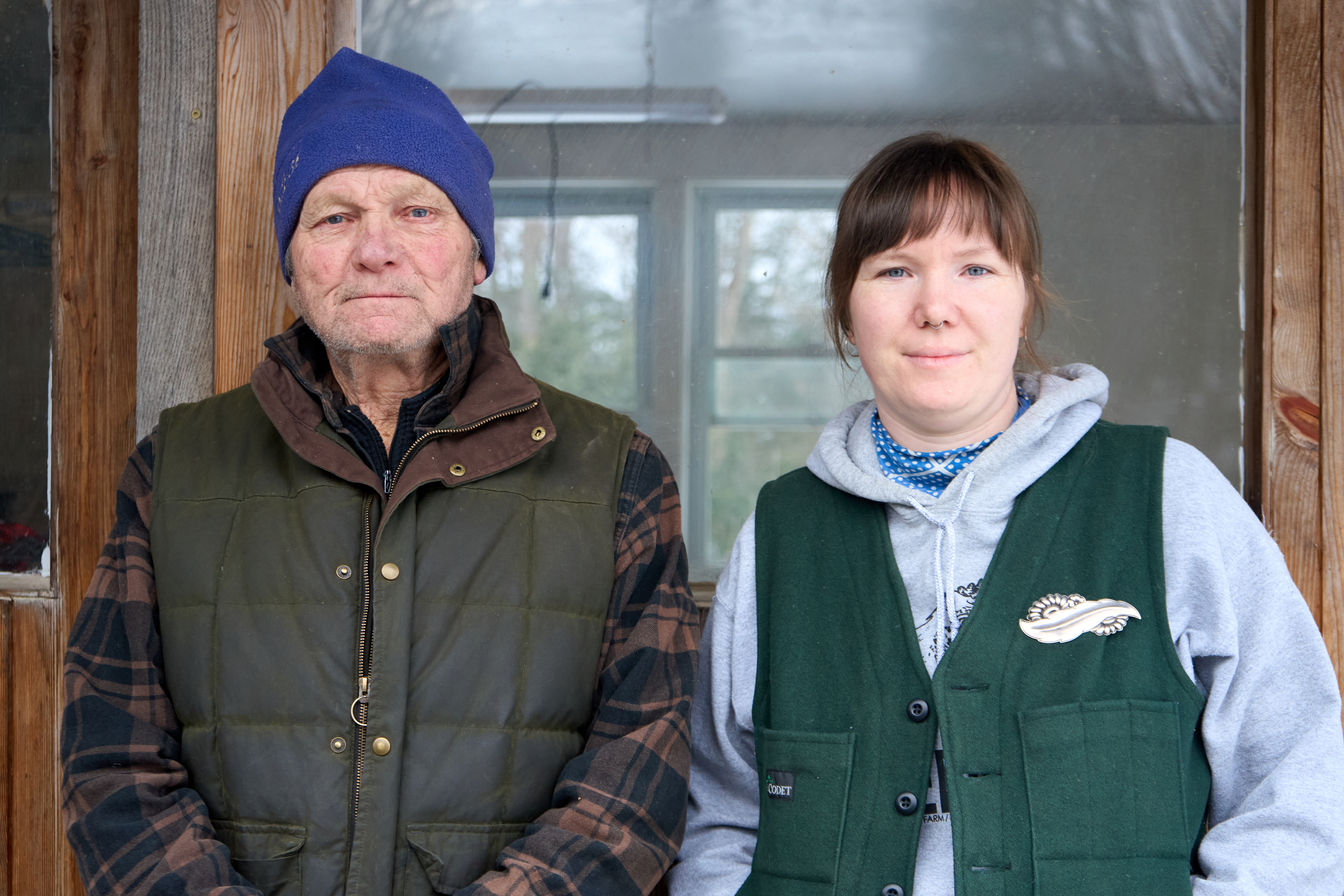 A father and his adult daughter stand next to each other dressed for cold weather